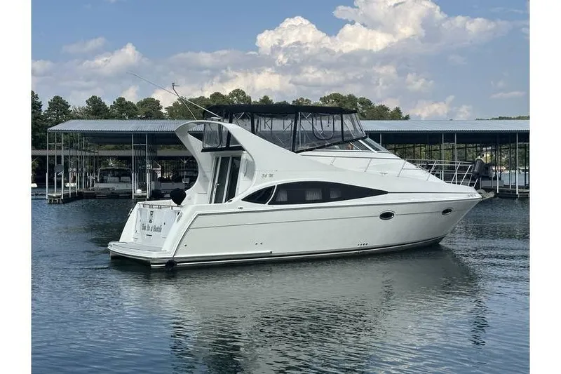  Yacht Photos Pics 2005 Carver 36 Mariner yacht docked on calm water under a partly cloudy sky.