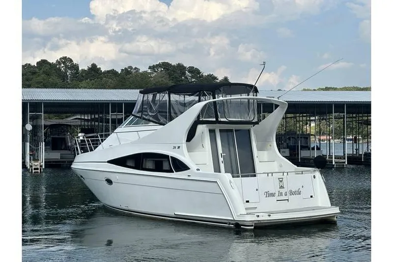  Yacht Photos Pics 2005 Carver 36 Mariner yacht docked on a calm lake under a cloudy sky.