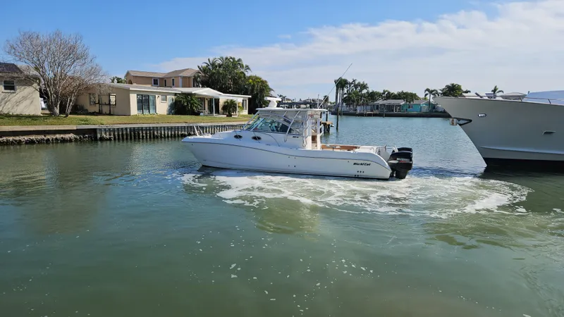 K Dee Yacht Photos Pics 2008 World Cat 320 EC boat cruising in a calm residential canal.