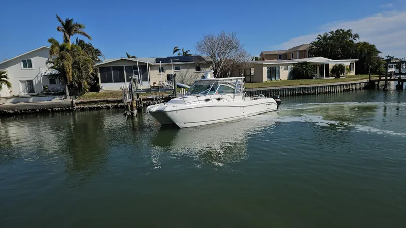 K Dee Yacht Photos Pics 2008 World Cat 320 EC boat cruising near waterfront homes.