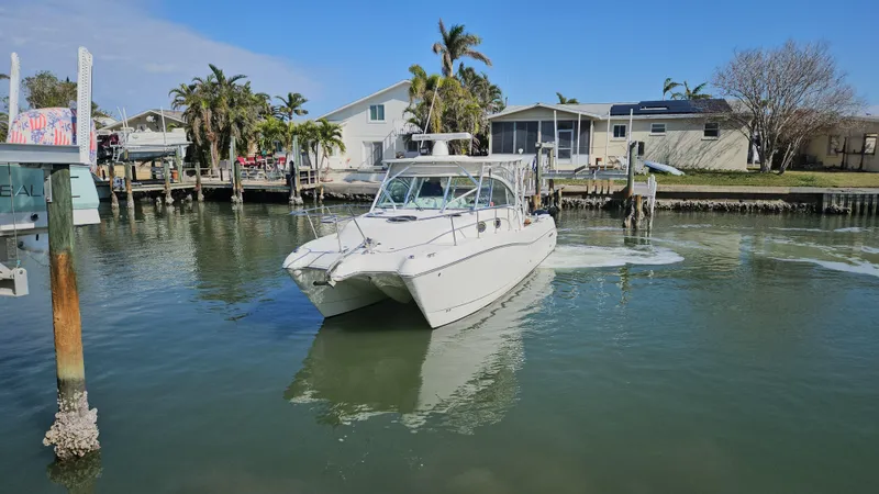 K Dee Yacht Photos Pics 2008 World Cat 320 EC boat navigating a calm residential canal.