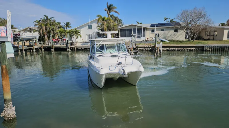 K Dee Yacht Photos Pics 2008 World Cat 320 EC boat navigating a calm residential canal.