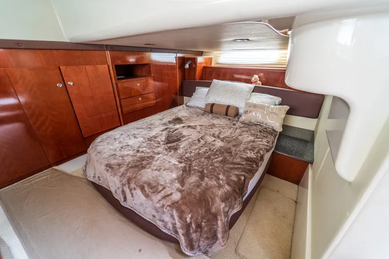  Yacht Photos Pics Luxurious bedroom interior of 2009 Meridian 441 Sedan yacht with plush bedding and wooden cabinetry.