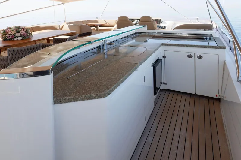  Yacht Photos Pics Luxurious outdoor kitchen on 2010 Princess Flybridge 85 Motor Yacht with elegant seating and floral arrangement.