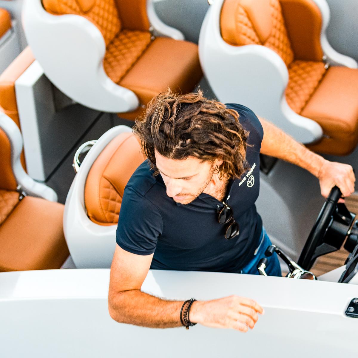 Man steering Skipper 120S Desire boat, 2017 model, with stylish seating.