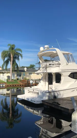  Yacht Photos Pics 2006 Silverton 34 Convertible yacht docked by palm trees under clear blue sky.