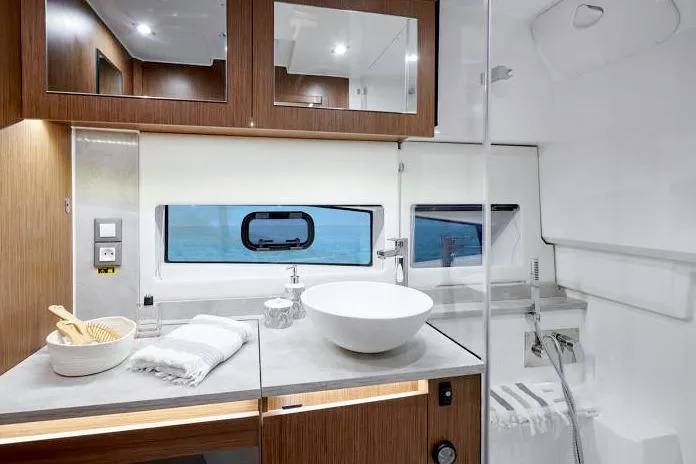  Yacht Photos Pics Luxurious bathroom interior of 2023 Jeanneau Leader 12.5 WA yacht, featuring modern fixtures and wood accents.