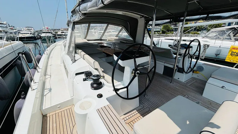  Yacht Photos Pics 2024 Beneteau Oceanis Yacht 54, spacious deck and dual steering wheels in marina setting.