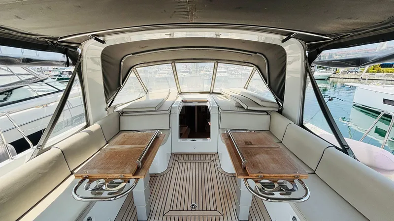  Yacht Photos Pics Luxurious cockpit of 2024 Beneteau Oceanis Yacht 54 with elegant seating and wooden tables.