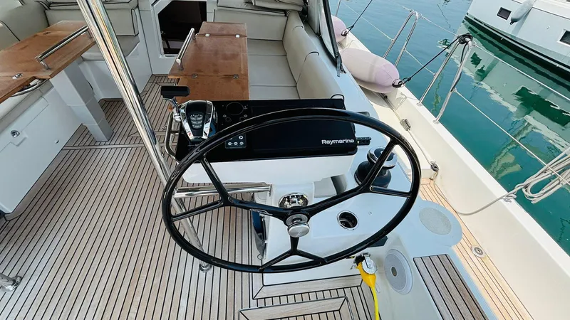  Yacht Photos Pics 2024 Beneteau Oceanis Yacht 54 cockpit with steering wheel and navigation equipment.