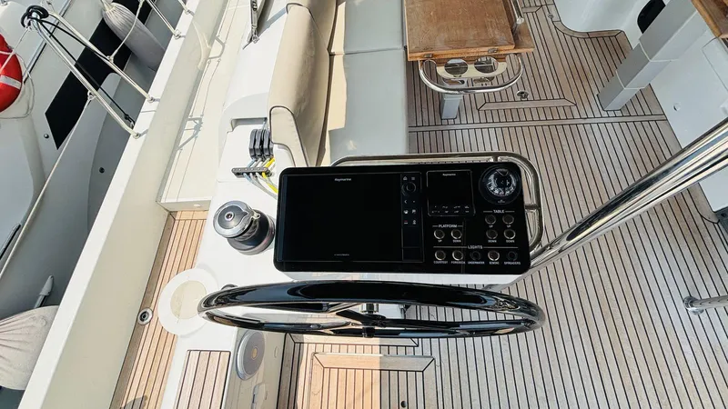  Yacht Photos Pics 2024 Beneteau Oceanis Yacht 54 cockpit with steering wheel and navigation controls.