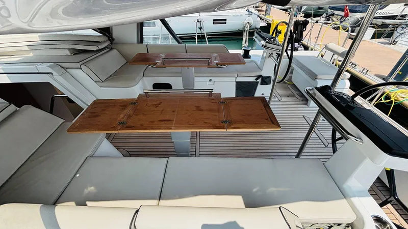  Yacht Photos Pics Luxurious interior of 2024 Beneteau Oceanis Yacht 54 with elegant seating and wooden tables.