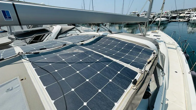  Yacht Photos Pics 2024 Beneteau Oceanis Yacht 54 with solar panels on deck, docked in marina.