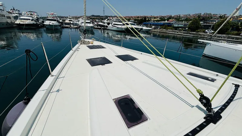  Yacht Photos Pics 2024 Beneteau Oceanis Yacht 54 docked in a marina, showcasing sleek deck design.