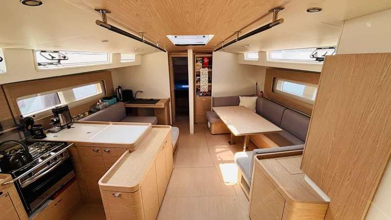 Yacht Photos Pics Luxurious interior of 2024 Beneteau Oceanis Yacht 54, featuring modern kitchen and seating area.