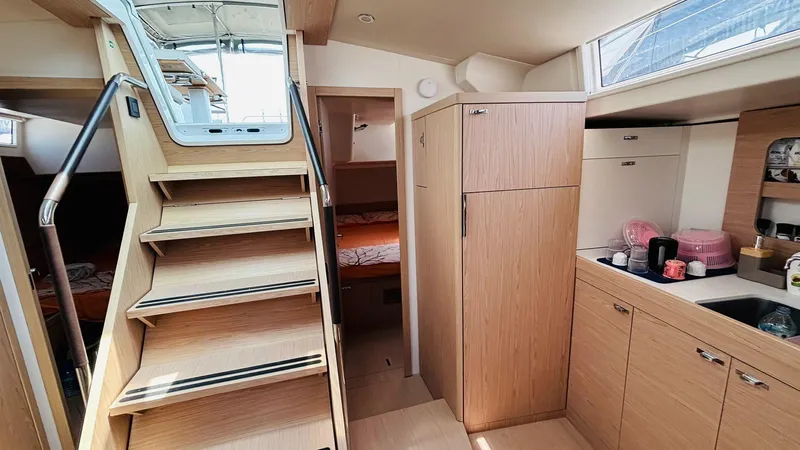  Yacht Photos Pics Interior of 2024 Beneteau Oceanis Yacht 54, featuring modern kitchen and wooden cabinetry.