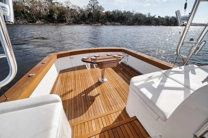  Yacht Photos Pics 1996 Garlington 44 Express boat deck with wooden flooring, overlooking a serene water view.