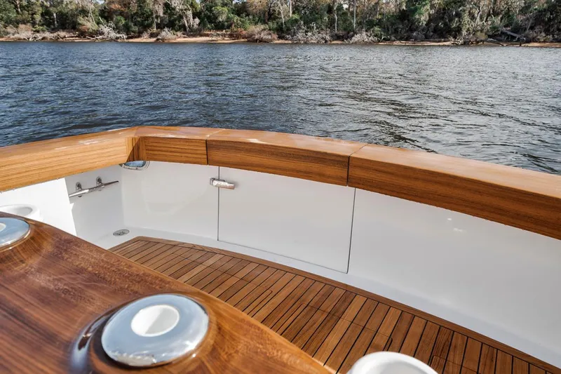  Yacht Photos Pics Garlington 44 Express 1996 boat deck with wooden finish, overlooking calm water and shoreline.