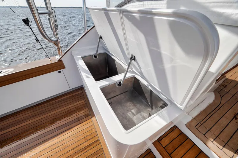  Yacht Photos Pics Open storage compartments on 1996 Garlington 44 Express boat deck, featuring wooden flooring.