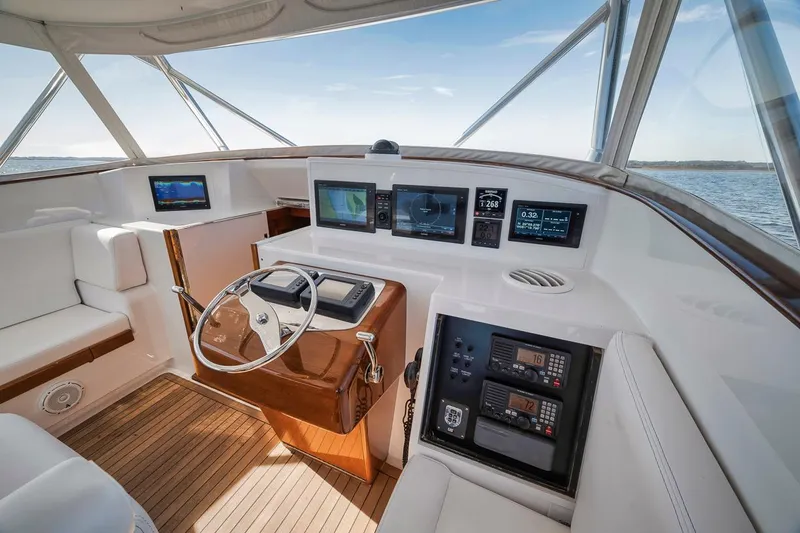  Yacht Photos Pics 1996 Garlington 44 Express yacht cockpit with modern navigation equipment and wooden accents.