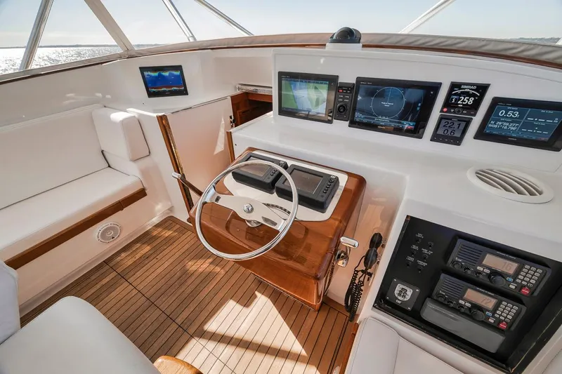  Yacht Photos Pics 1996 Garlington 44 Express yacht helm with modern navigation equipment and wooden accents.