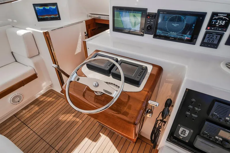  Yacht Photos Pics 1996 Garlington 44 Express helm with modern navigation equipment and wooden accents.