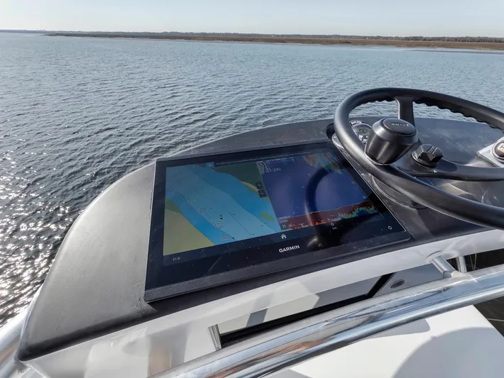  Yacht Photos Pics Garlington 44 Express 1996 boat helm with Garmin navigation display on calm water.