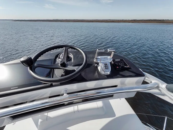  Yacht Photos Pics Helm of 1996 Garlington 44 Express yacht with steering wheel and controls, overlooking calm waters.