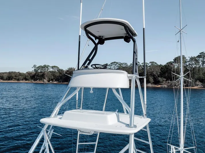  Yacht Photos Pics 1996 Garlington 44 Express boat tower with helm, on calm water, clear sky background.