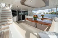 Luxurious Ocean Alexander 100 MY yacht deck with elegant seating and scenic waterfront view.