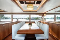Luxurious dining area on 2020 Ocean Alexander 100 MY yacht with elegant wood finishes.