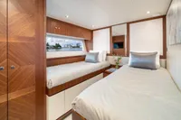 Luxurious twin bedroom on 2020 Ocean Alexander 100 MY yacht, featuring elegant wood finishes.