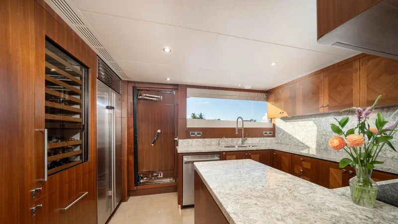 Iridescence Yacht Photos Pics Luxurious kitchen interior on 2020 Ocean Alexander 100 MY yacht, featuring wood cabinetry and marble countertops.