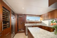 Luxurious kitchen interior on 2020 Ocean Alexander 100 MY yacht, featuring wood cabinetry and marble countertops.