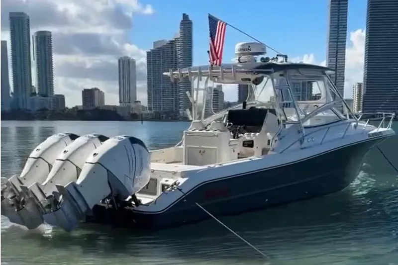  Yacht Photos Pics 2010 Triton 351 Express boat with triple engines, docked near city skyline.