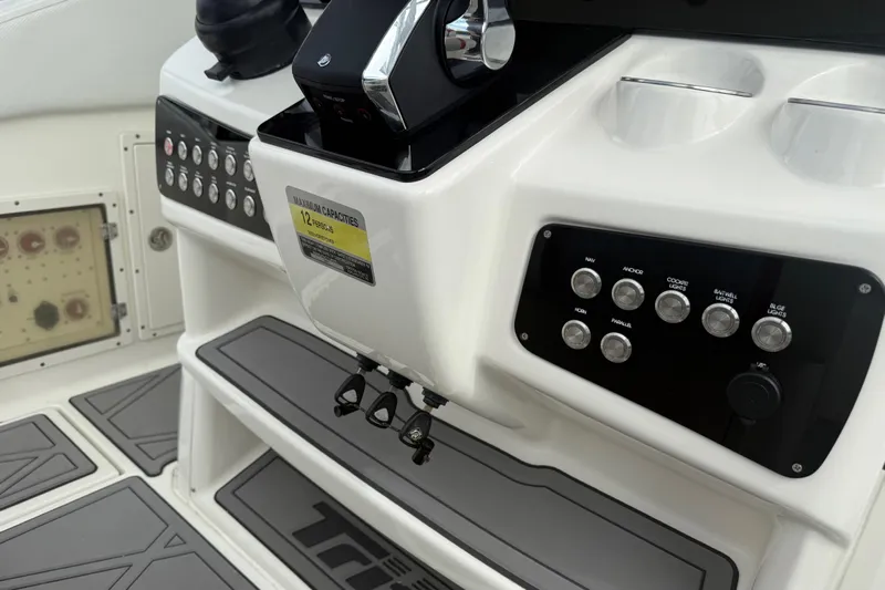  Yacht Photos Pics Control panel of a 2010 Triton 351 Express boat with labeled switches and capacity sign.