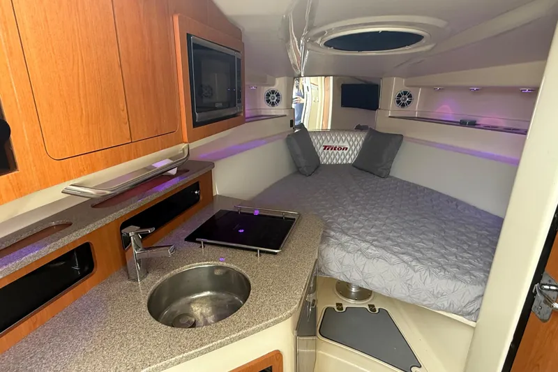  Yacht Photos Pics Luxurious interior of 2010 Triton 351 Express boat with kitchenette and cozy sleeping area.
