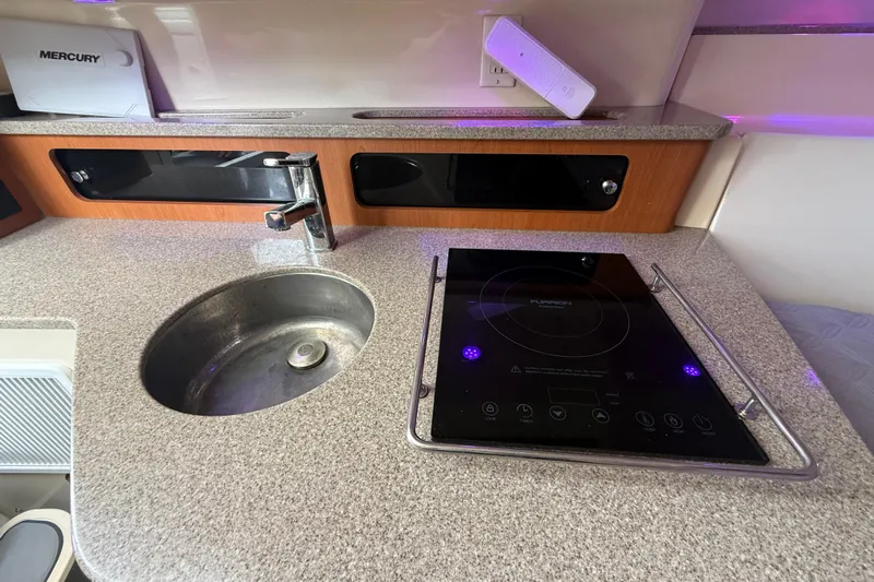  Yacht Photos Pics Compact kitchen area in 2010 Triton 351 Express with sink and induction cooktop.