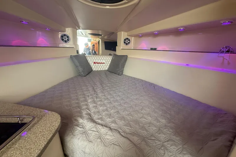  Yacht Photos Pics Interior cabin of 2010 Triton 351 Express boat with cozy bedding and ambient lighting.