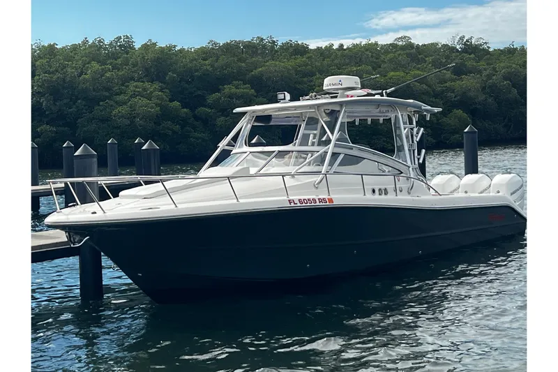  Yacht Photos Pics 2010 Triton 351 Express boat docked on calm water with lush greenery background.