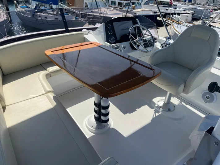 Eleven Seven Yacht Photos Pics 2013 Beneteau Swift Trawler 34 interior with helm, seating, and polished wooden table.