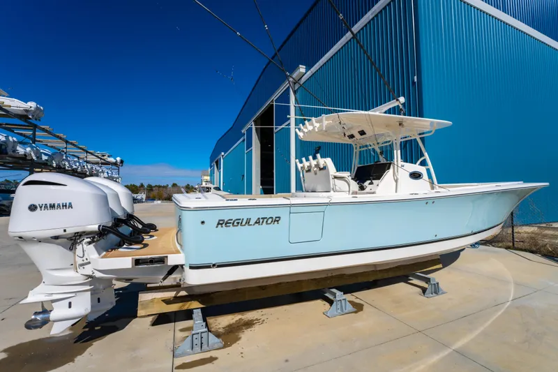  Yacht Photos Pics 2019 Regulator 34 boat with Yamaha engines, docked near a blue building.