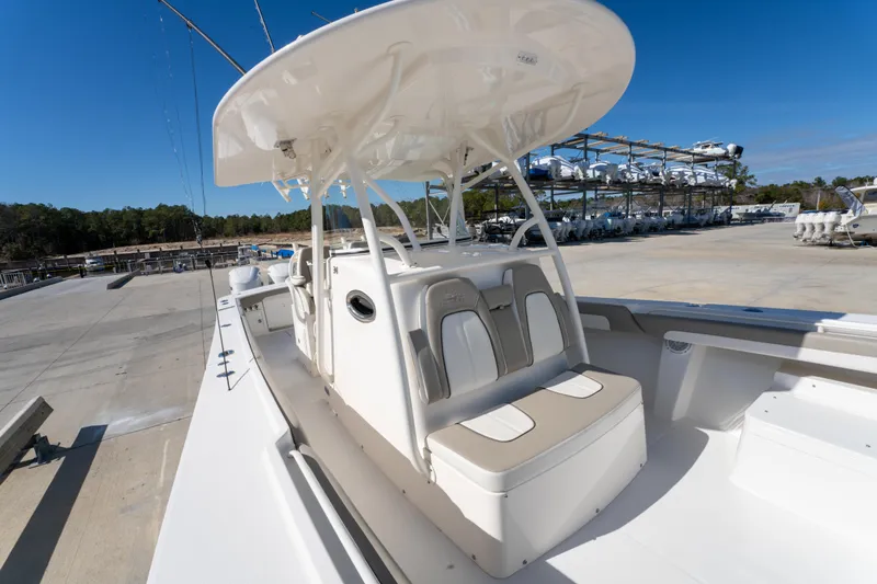  Yacht Photos Pics 2019 Regulator 34 boat with seating and canopy, parked in a marina under clear blue sky.