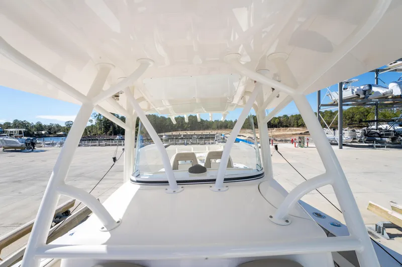  Yacht Photos Pics 2019 Regulator 34 boat with sturdy white framework and clear windshield at a marina.