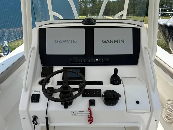  Yacht Photos Pics 2019 Regulator 34 boat helm with dual Garmin displays and steering wheel.