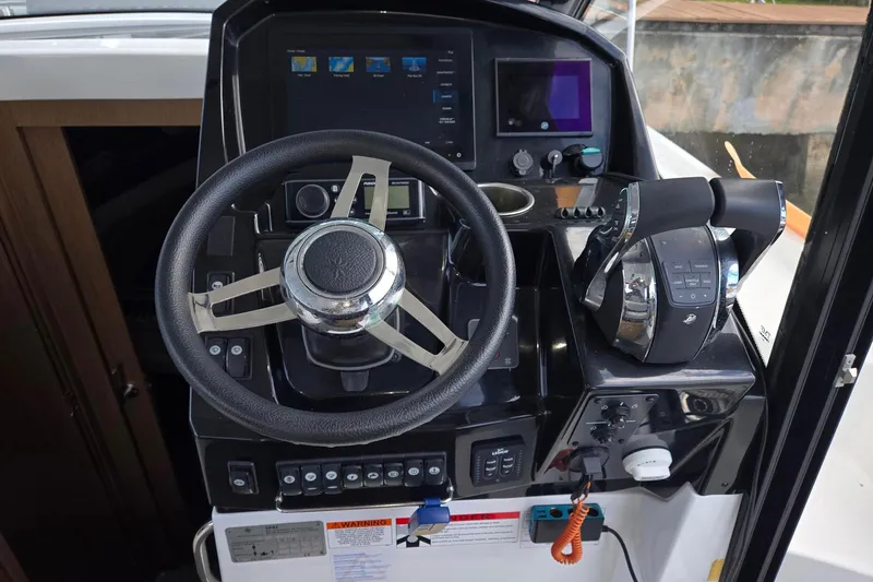  Yacht Photos Pics 2021 Jeanneau NC 895 helm with steering wheel, controls, and navigation display.