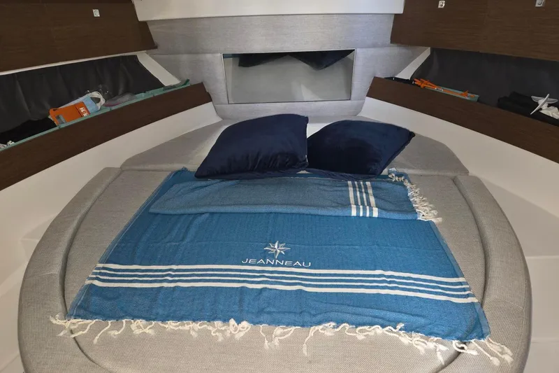  Yacht Photos Pics Interior of 2021 Jeanneau NC 895 boat with cozy bed and blue blanket.
