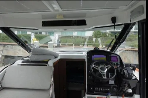  Yacht Photos Pics Interior view of 2021 Jeanneau NC 895 boat cockpit with steering wheel and navigation equipment.