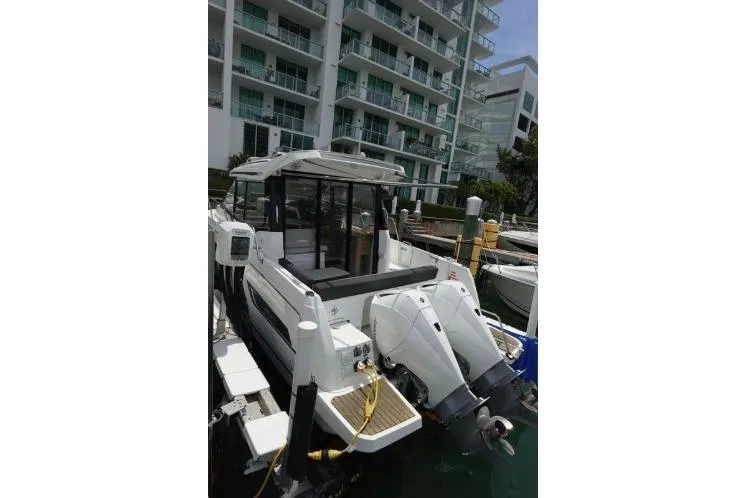  Yacht Photos Pics 2021 Jeanneau NC 895 boat docked near modern apartments.