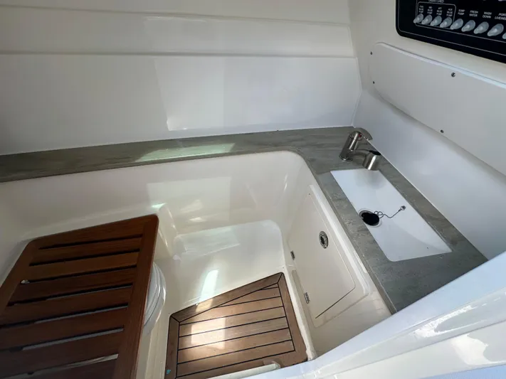  Yacht Photos Pics 2023 Boston Whaler 320 Vantage interior with sink and wooden accents.